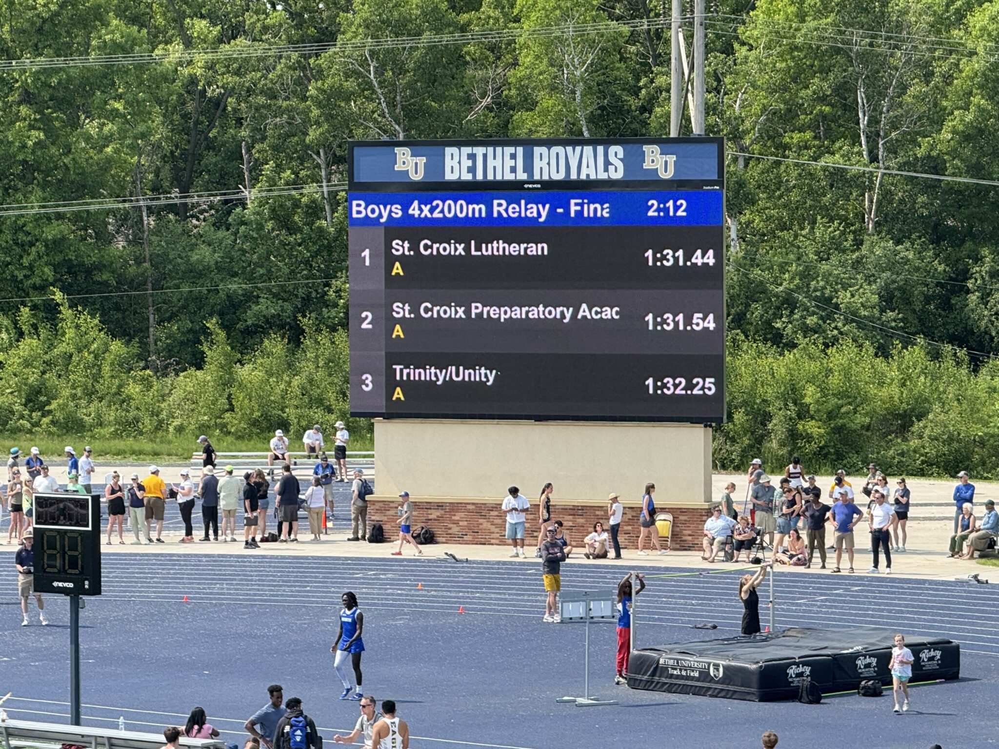 Track meet scoreboard showing relay results.