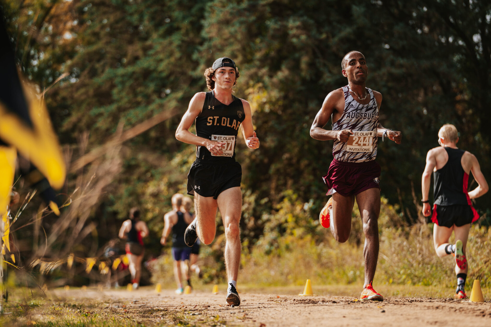 Two athletes running in a cross-country race.